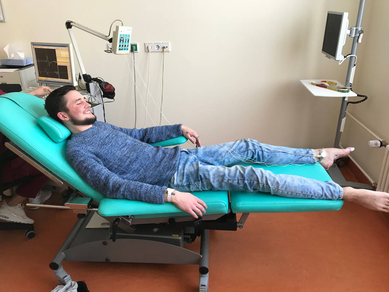 Igor on a medical bed during a procedure, smiling